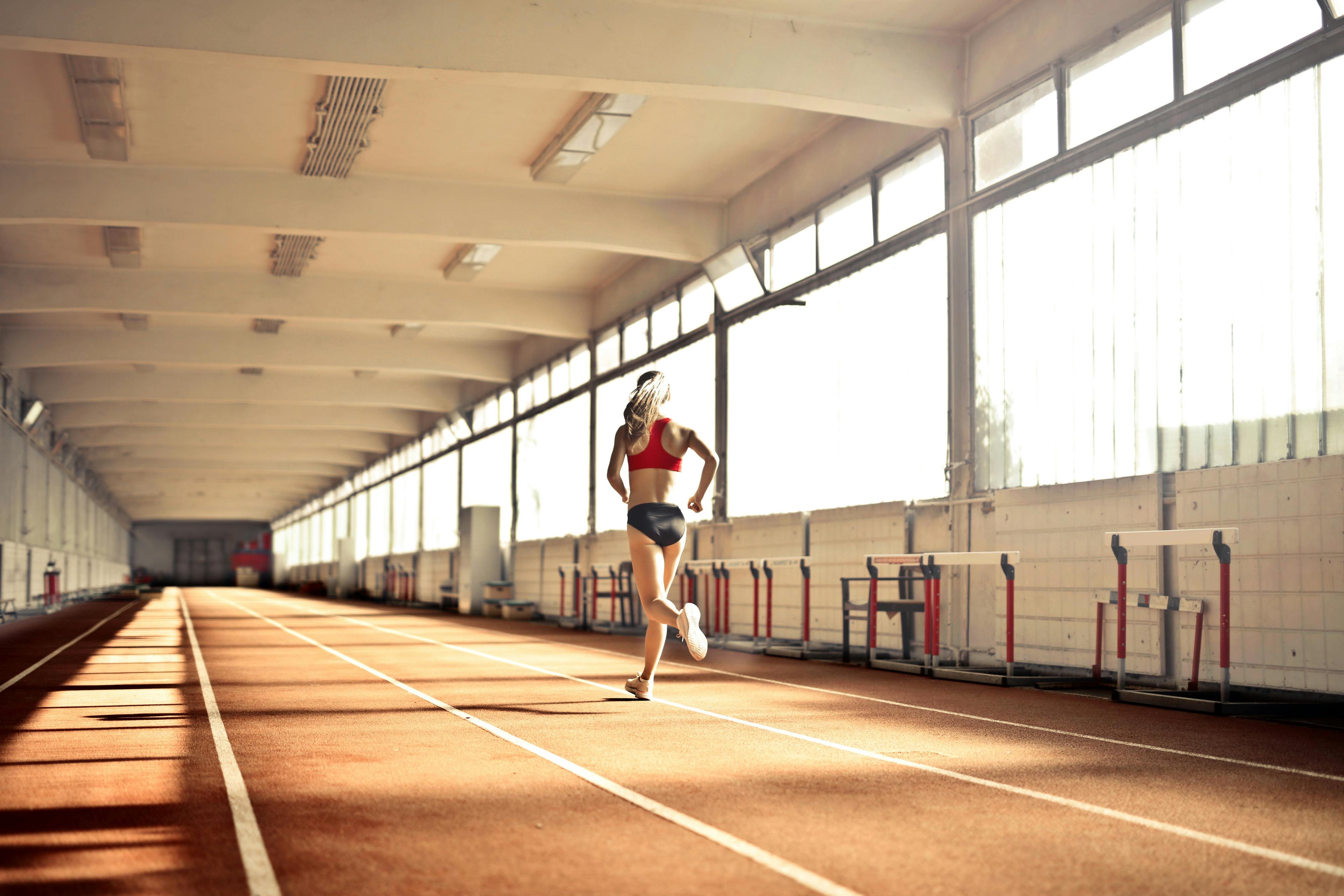 Female athlete running on indoor track